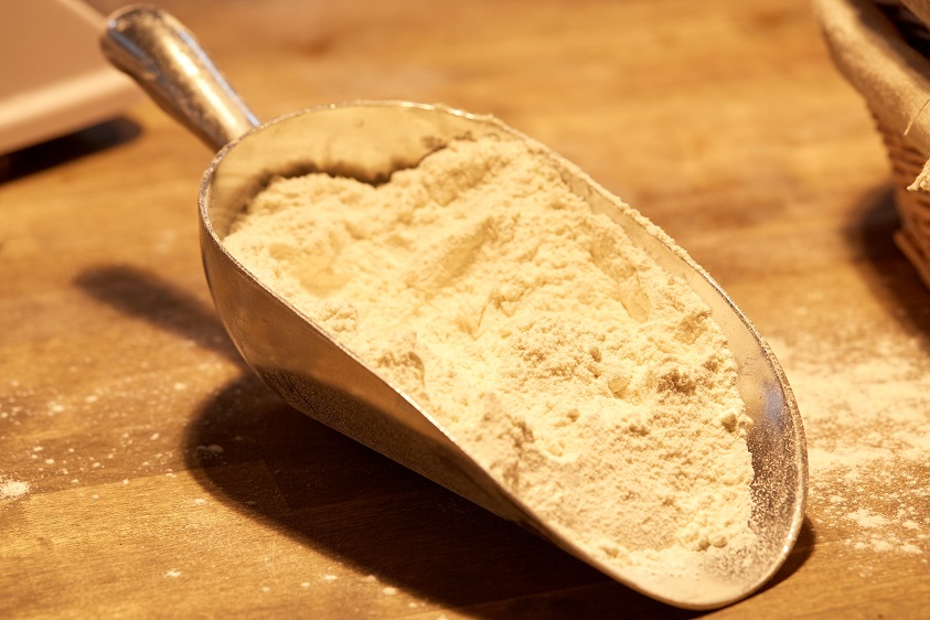 flour in bakery scoop on wooden kitchen table